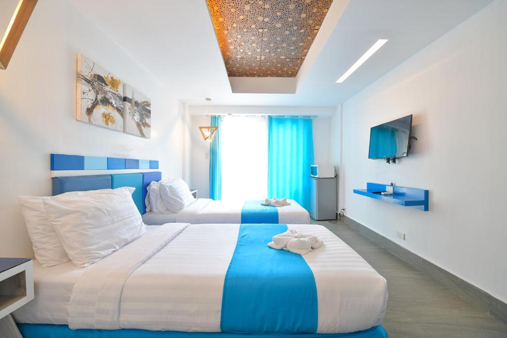 a hotel room with two beds and a television at One Azul Boracay in Boracay