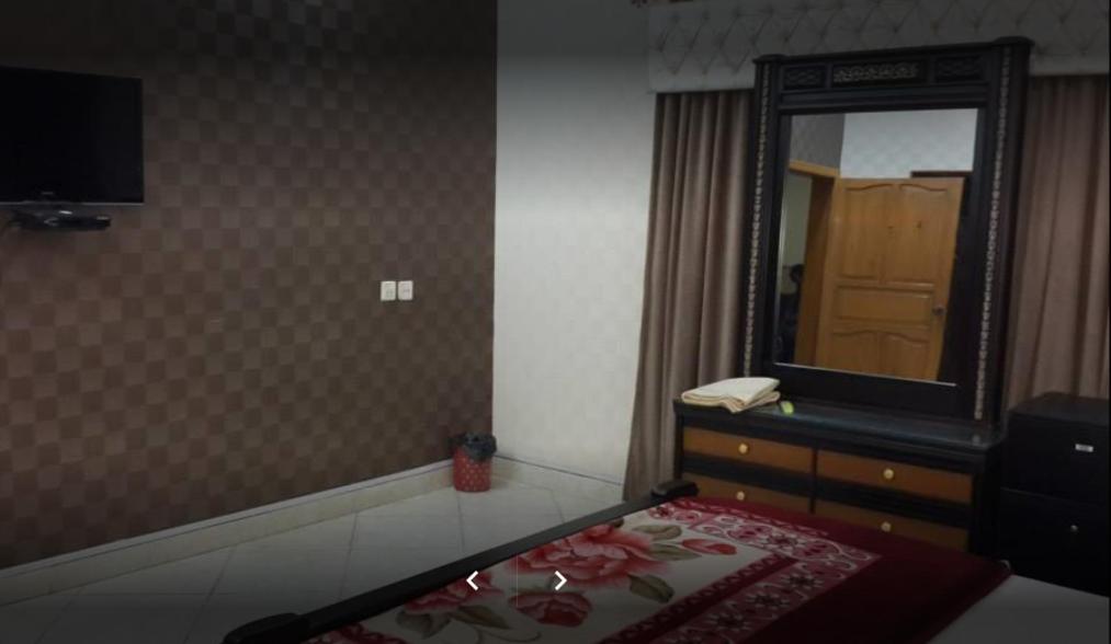 1 dormitorio con espejo y 1 cama con tocador en Holiday Inn Guest House, en Kalar Goth