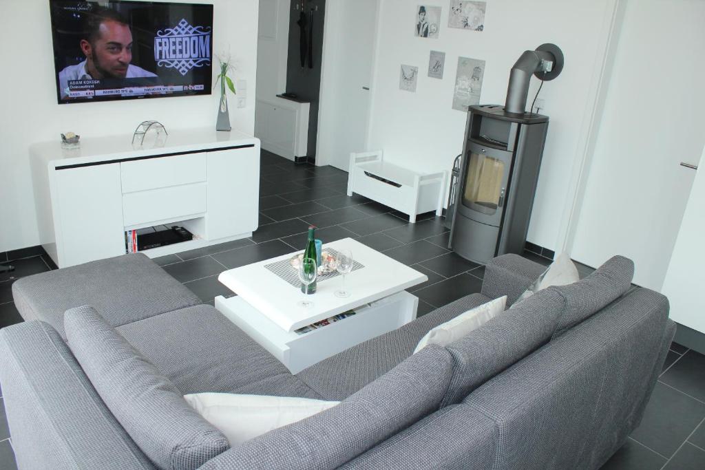 sala de estar con sofá y TV en Ferienwohnung Küstenzauber 20, en Großenbrode