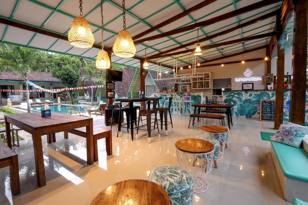 un restaurante con mesas y sillas y una piscina en Makarma Resort Lombok, en Senggigi 