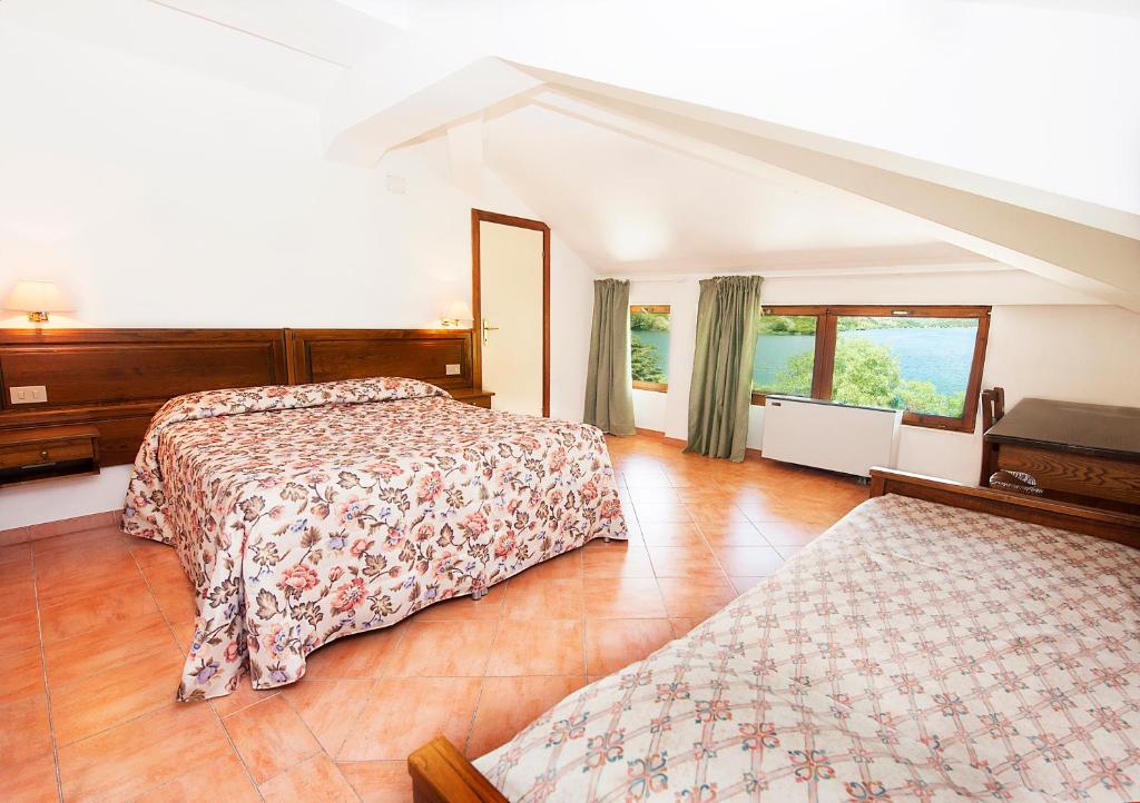 a bedroom with two beds and a large window at Hotel Acquevive in Scanno