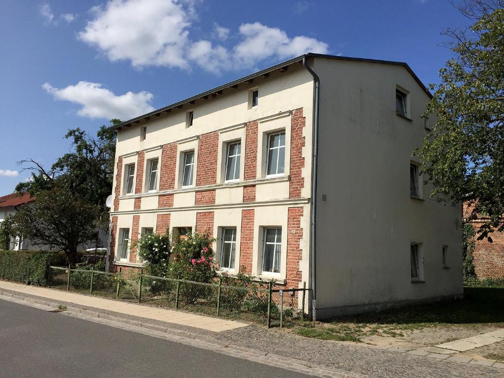 een wit gebouw aan de straatkant bij Ferienwohnung Elly in Altefähr