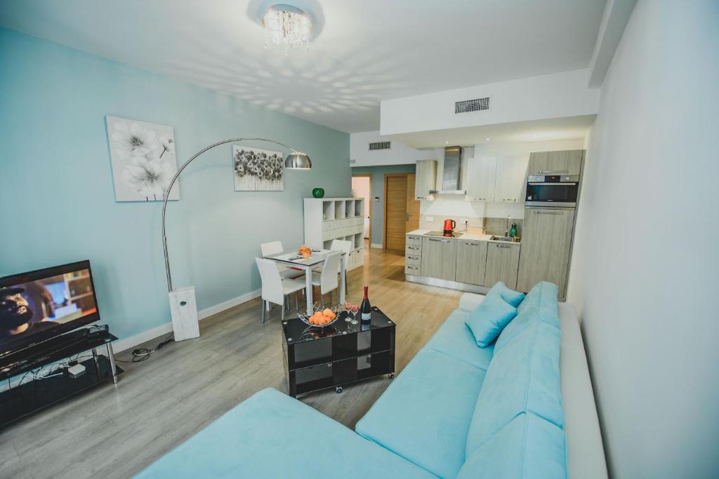 un salon avec un canapé bleu et une cuisine dans l'établissement AzurAppart 3room Nice Promenade, à Nice