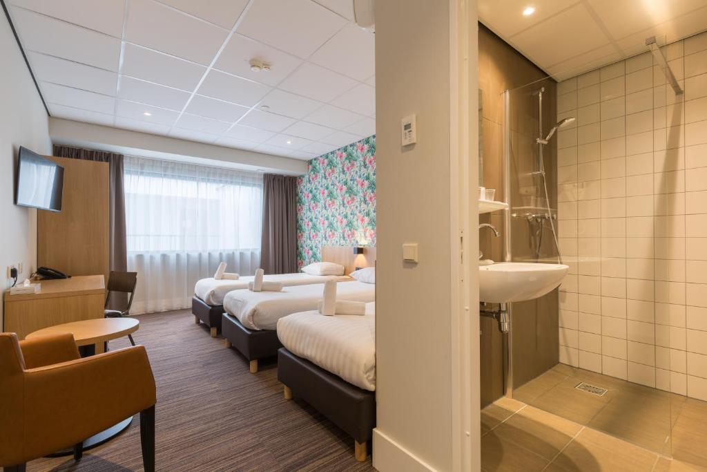 een hotelkamer met 4 bedden en een wastafel bij Best Western Amsterdam in Amsterdam