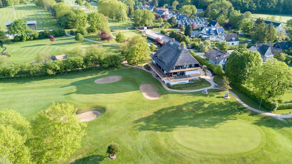 蒂門多爾費爾斯特蘭德的住宿－Strandgrün Golf- & Spa Resort，高尔夫球场空中景观和房子