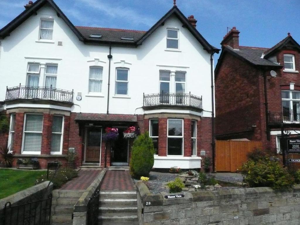 a white house with red brick at Manor View in Whitby