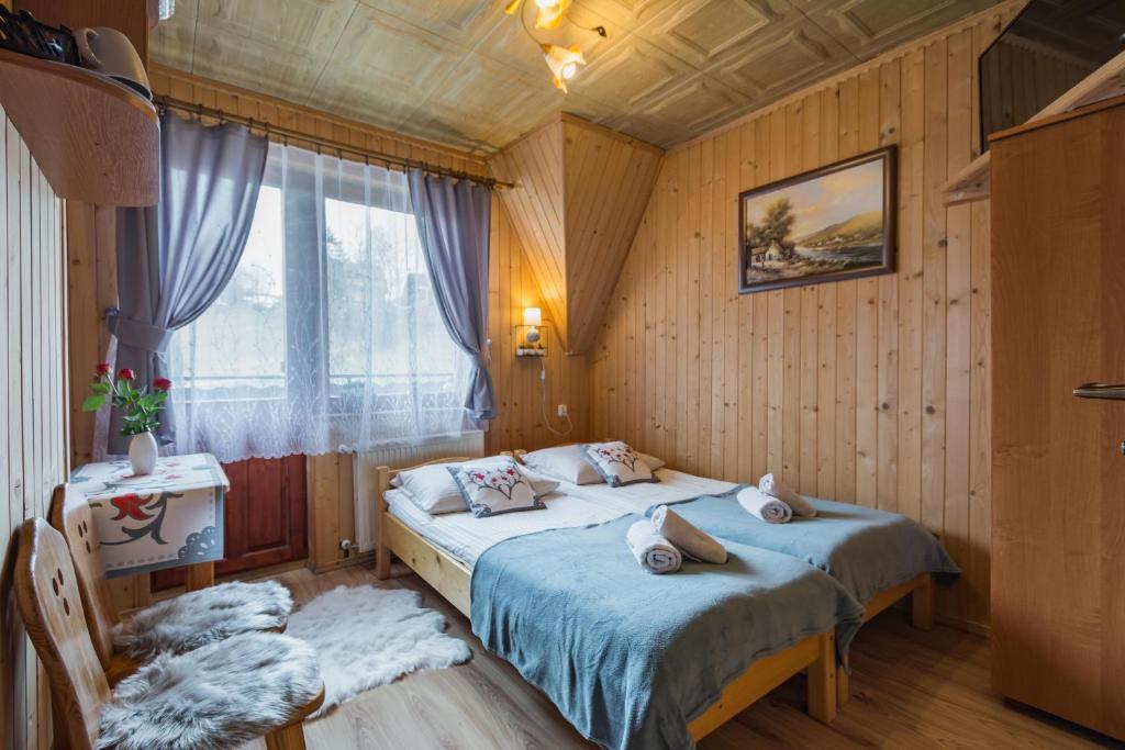 1 dormitorio con 2 camas y ventana en Agrotatry U Stachy en Bukowina Tatrzańska