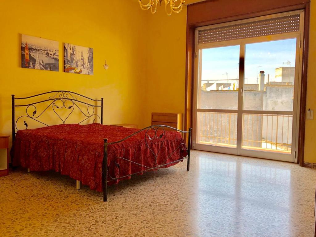 ガラトーネにあるAppartamento Cavourのベッドルーム1室(ベッド1台、大きな窓付)