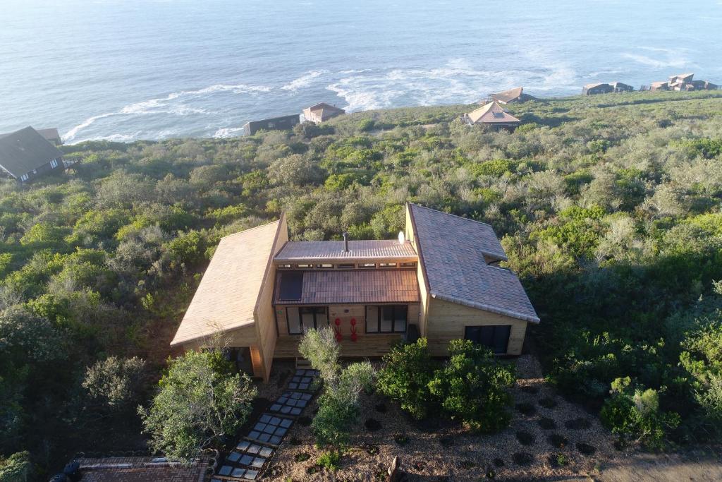 an aerial view of a house on a hill next to the ocean at Earth Wind and Ocean 33 in George