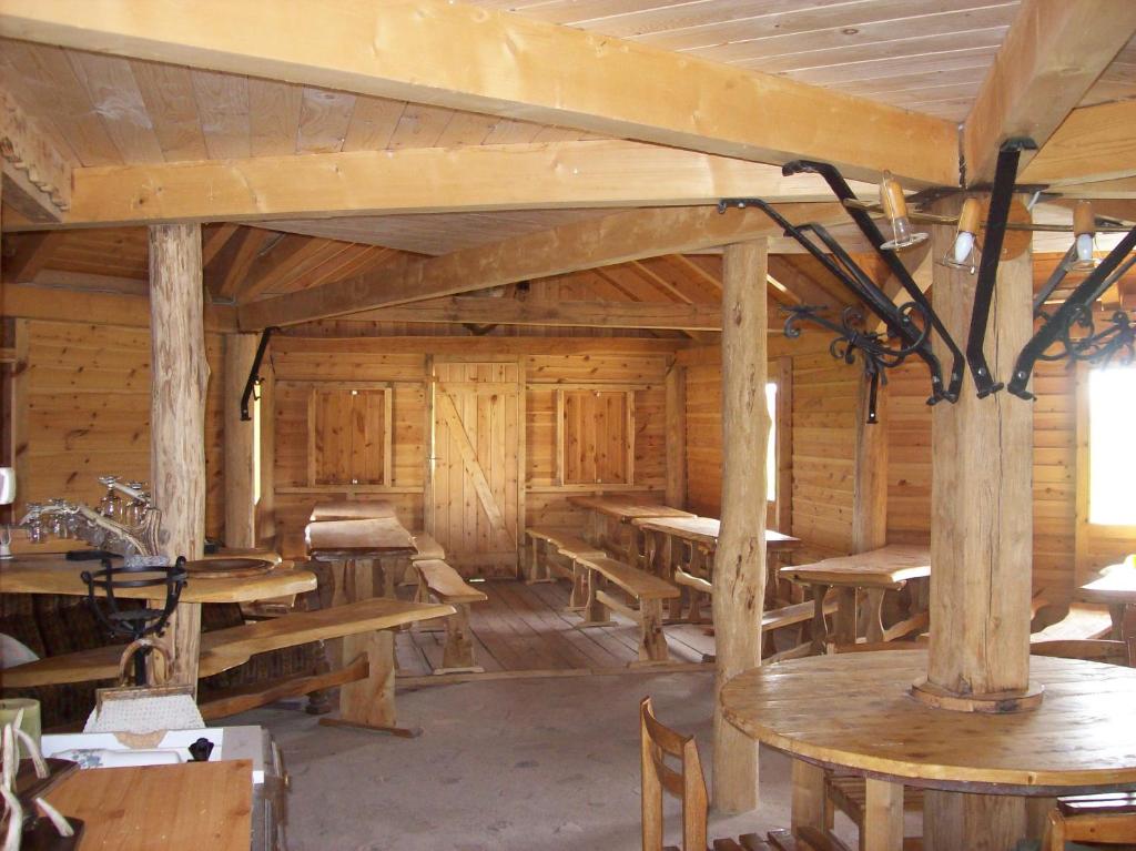 um quarto amplo com mesas de madeira e paredes de madeira em Lila Akác Vendégház em Dabrony