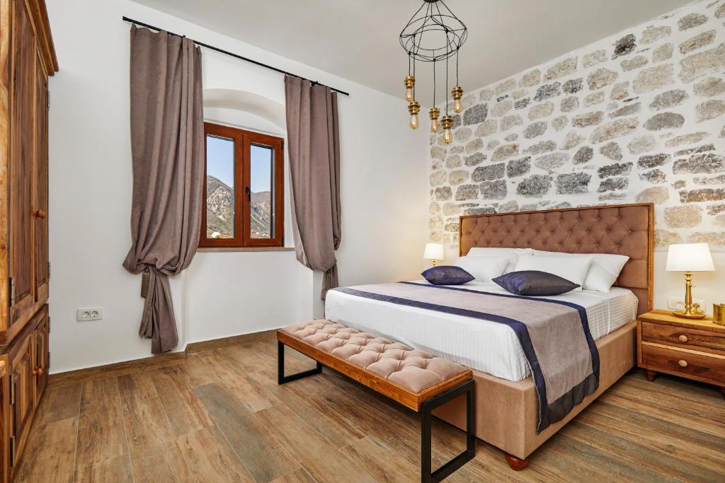 a bedroom with a bed and a stone wall at Three Dots by Todorovic Family in Kotor