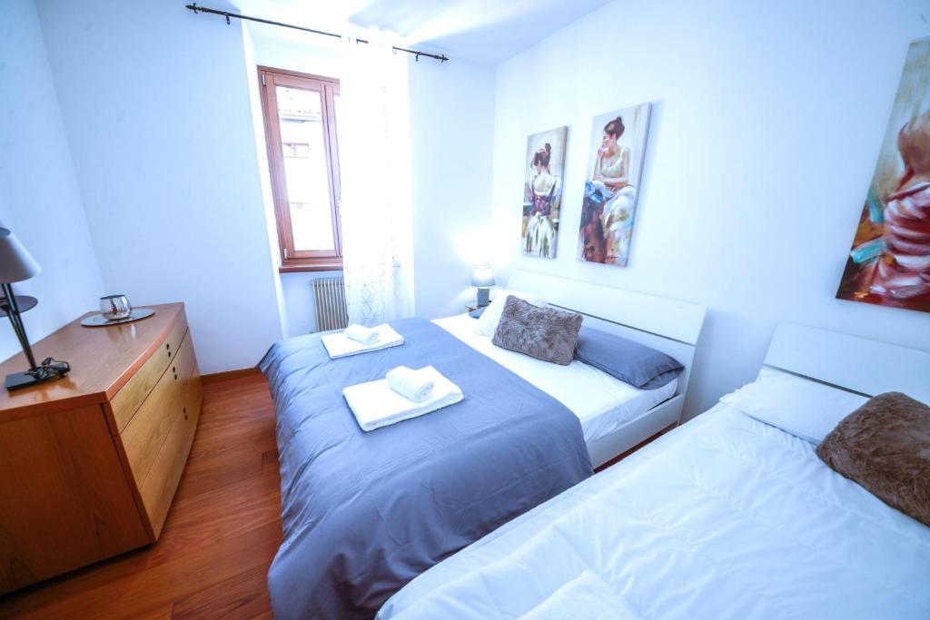 a bedroom with two beds and a dresser in it at City Heart in Riva del Garda