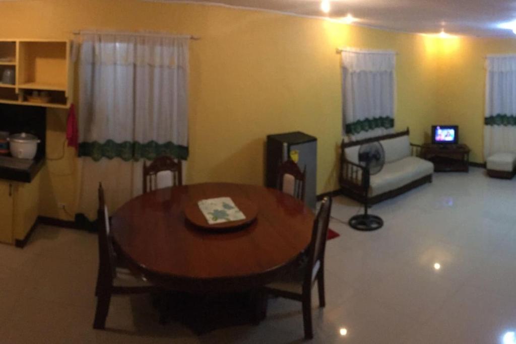 a living room with a table and a couch at Pines Mansion II in Butuan