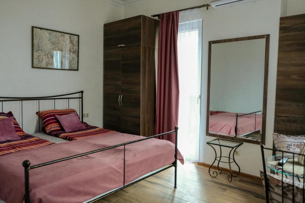 a bedroom with two beds and a mirror at 3 Studio in Tbilisi City