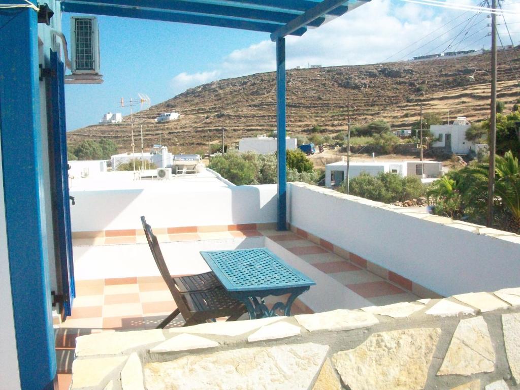a patio with a table and chairs on a balcony at Serifos Palace in Livadakia