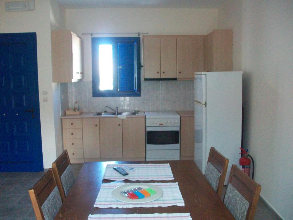 a kitchen with a table with chairs and a refrigerator at Serifos Palace in Livadakia