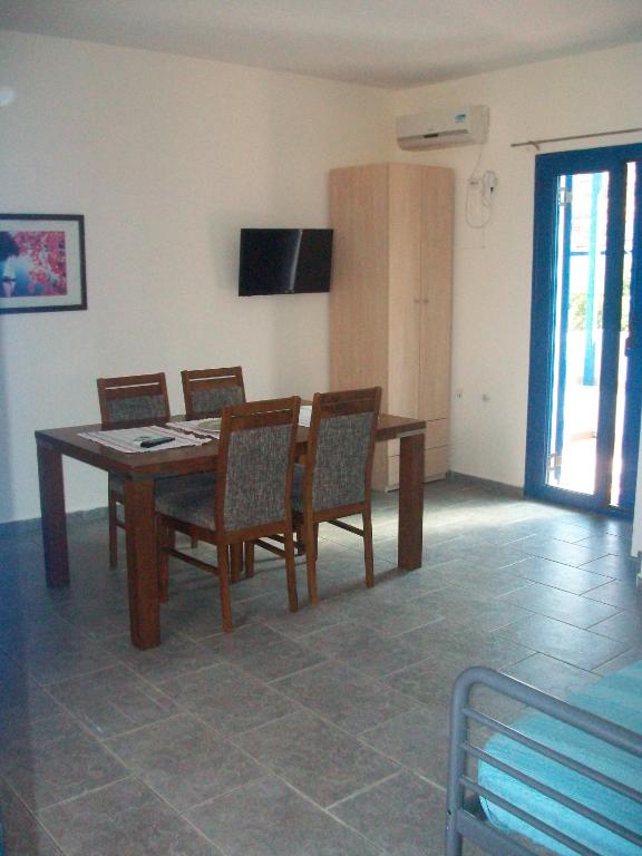 a dining room with a wooden table and chairs at Serifos Palace in Livadakia