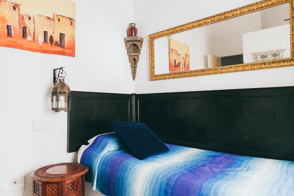 - une chambre avec un lit et un miroir dans l'établissement El Riad Andaluz, à Malaga