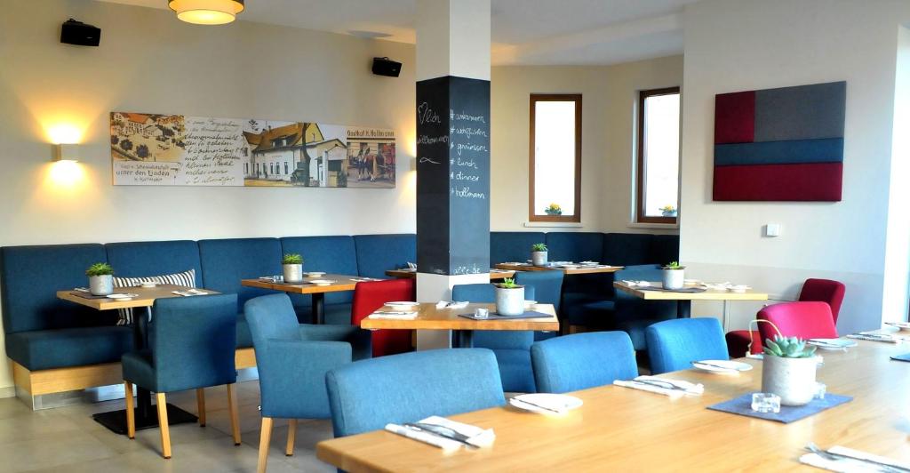 ein Esszimmer mit Tischen und blauen Stühlen in der Unterkunft Hotel Hollmann in Halle Westfalen