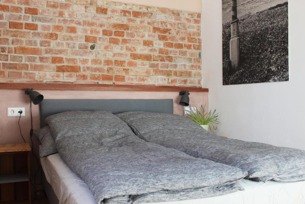 a bed in a room with a brick wall at Zur alten Scheune in Balingen