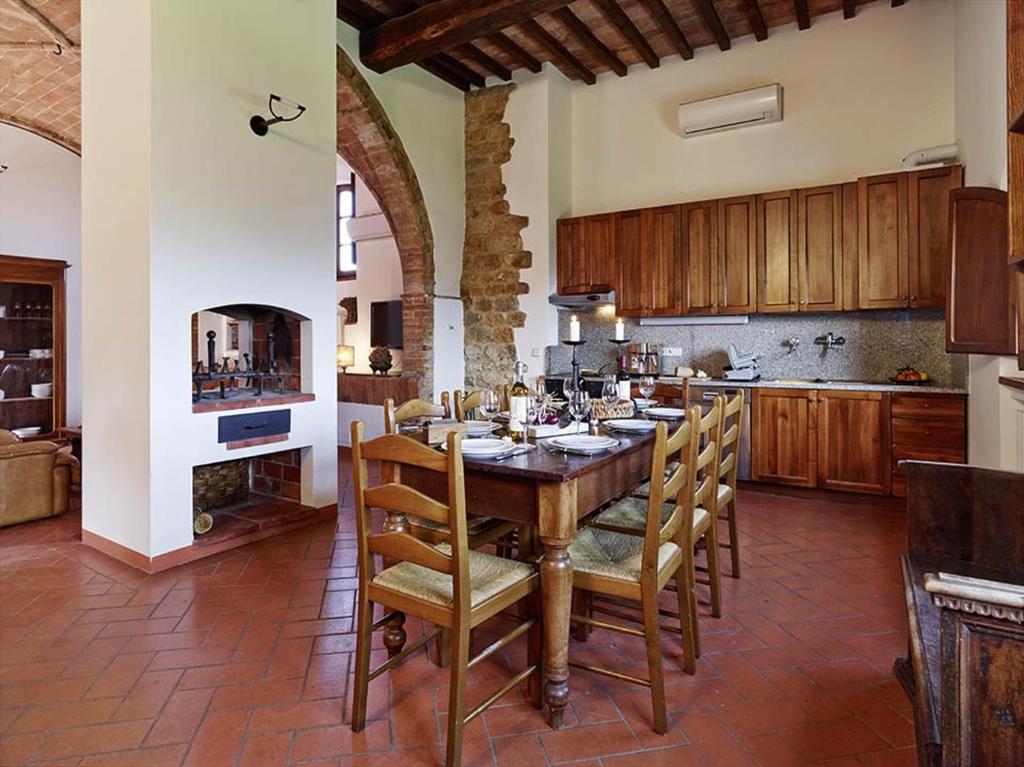 duża kuchnia z drewnianym stołem i krzesłami w obiekcie Agriturismo Podere Cortilla w mieście Volterra