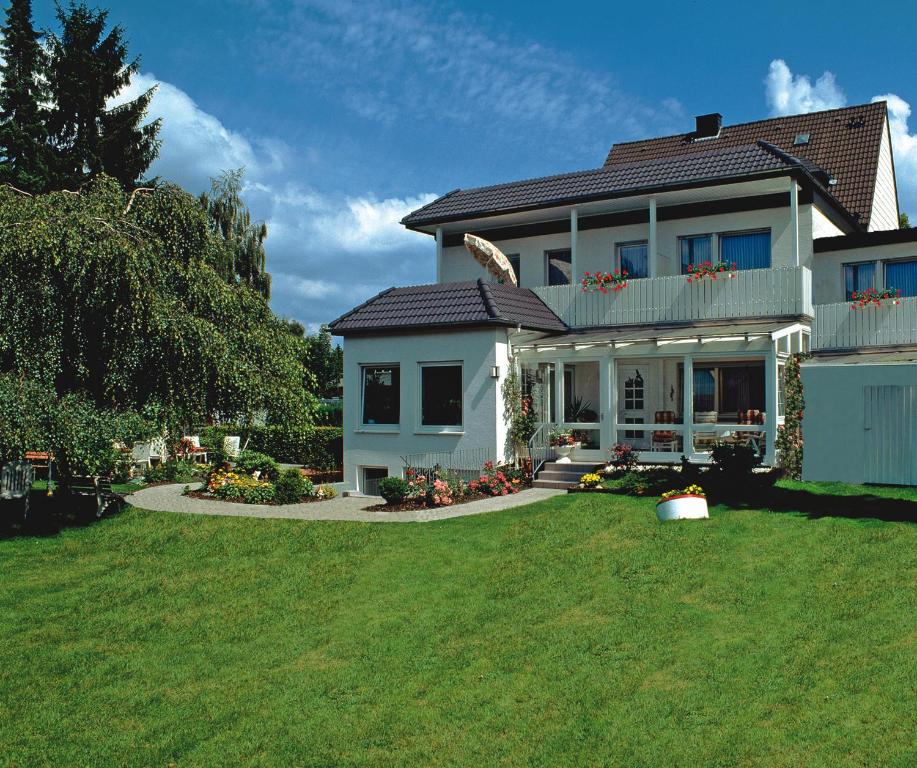 une maison blanche avec une pelouse verte devant elle dans l'établissement Haus Nethegau, à Bad Driburg