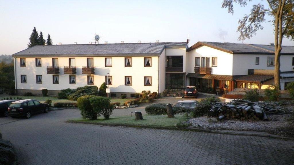 un grande edificio bianco con auto parcheggiate in un parcheggio di Gästehaus Loehnert GmbH a Coburg