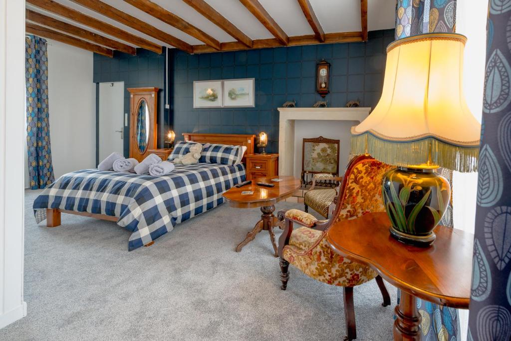 a bedroom with a bed and a table and a chair at AUBERGE DU NOYER in Londigny