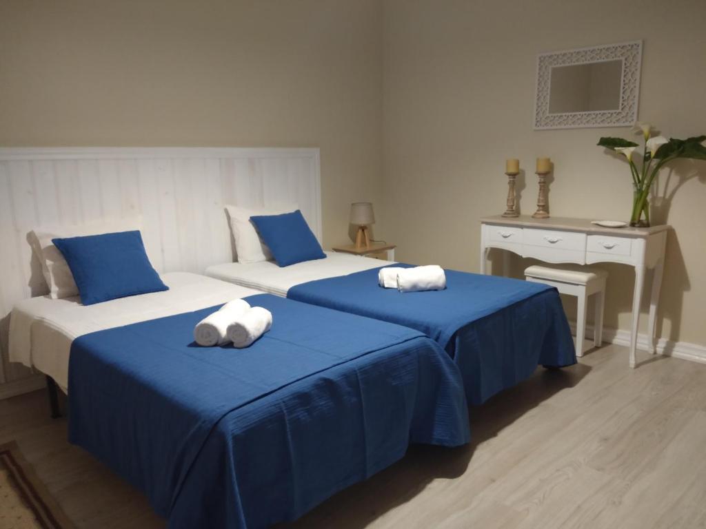 two beds in a room with blue and white at Lagoa´s House in Lagoa