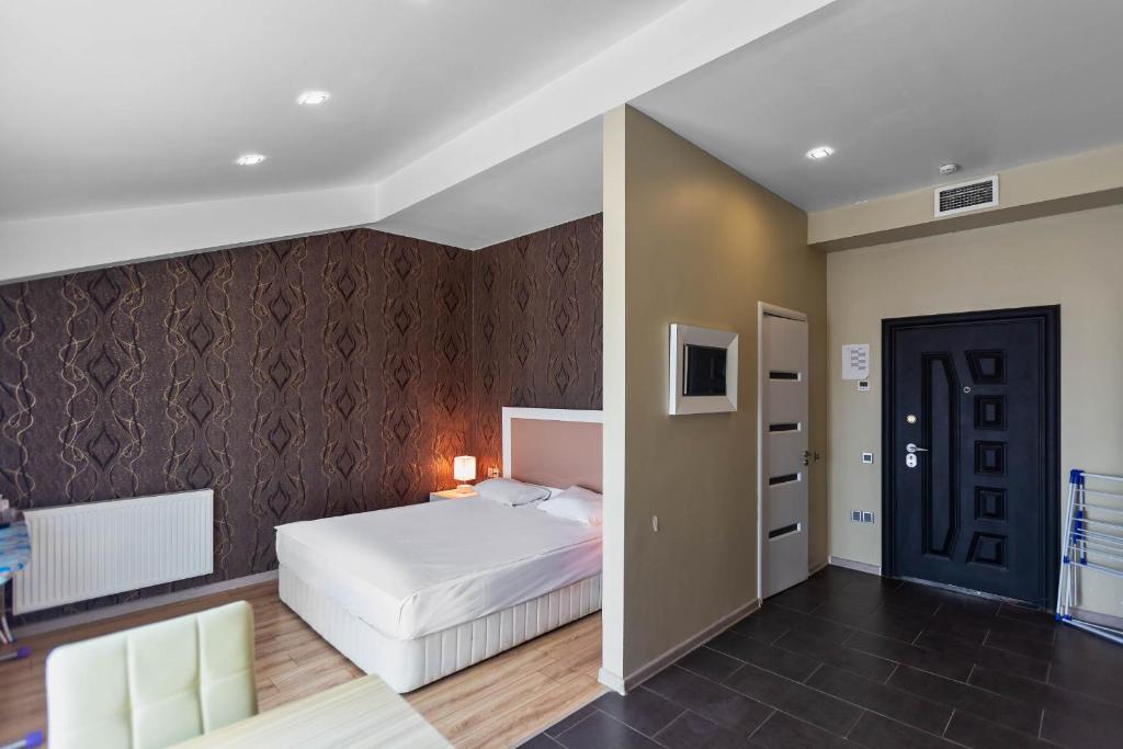 a bedroom with a white bed and a black wall at Diplomat Suites in Baku