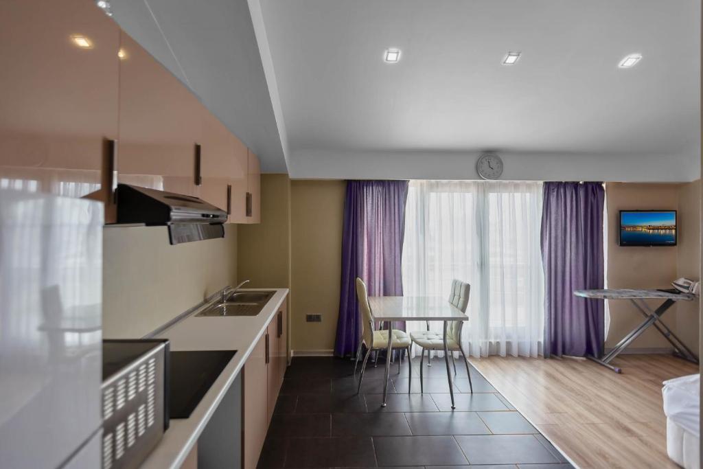a kitchen and dining room with a table and chairs at Diplomat Suites in Baku
