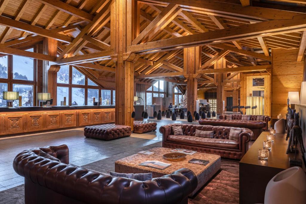 a large living room with leather furniture and wooden ceilings at Sport Hotel Hermitage & Spa in Soldeu