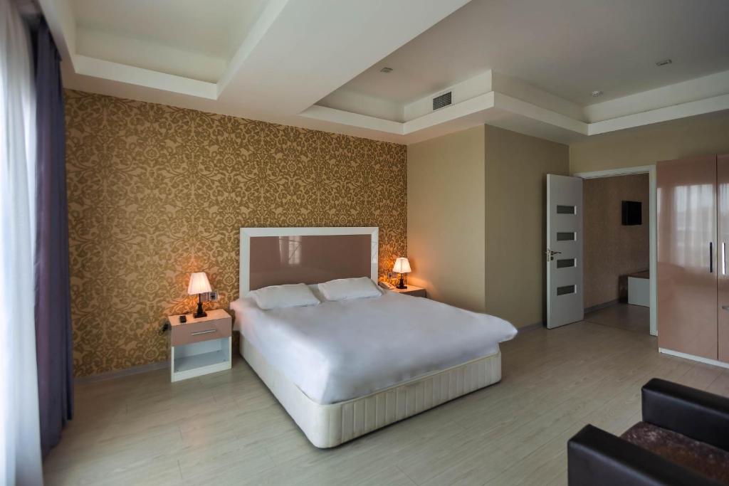 a bedroom with a bed and two night stands with lamps at Diplomat Suites in Baku