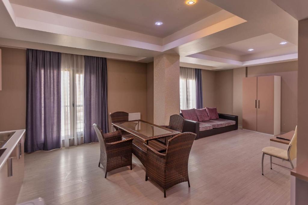 a living room with a table and chairs and a couch at Diplomat Suites in Baku