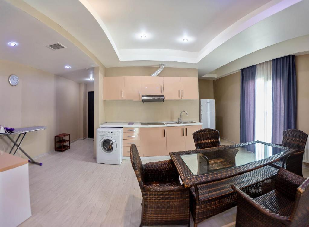 a kitchen with a glass table and chairs in a room at Diplomat Suites in Baku