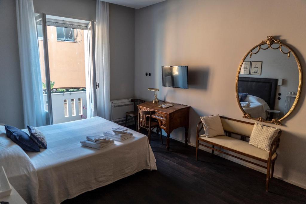 una camera con letto, specchio e sedia di Al Sale a Cagliari