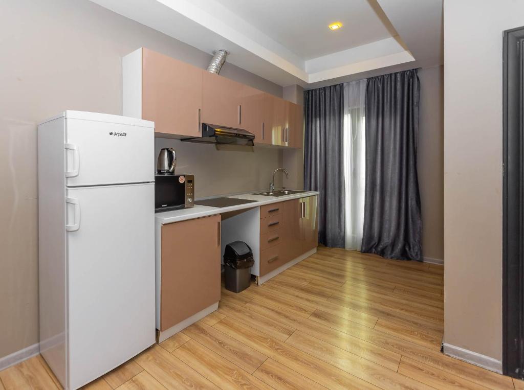 a kitchen with a white refrigerator in a room at Diplomat Suites in Baku