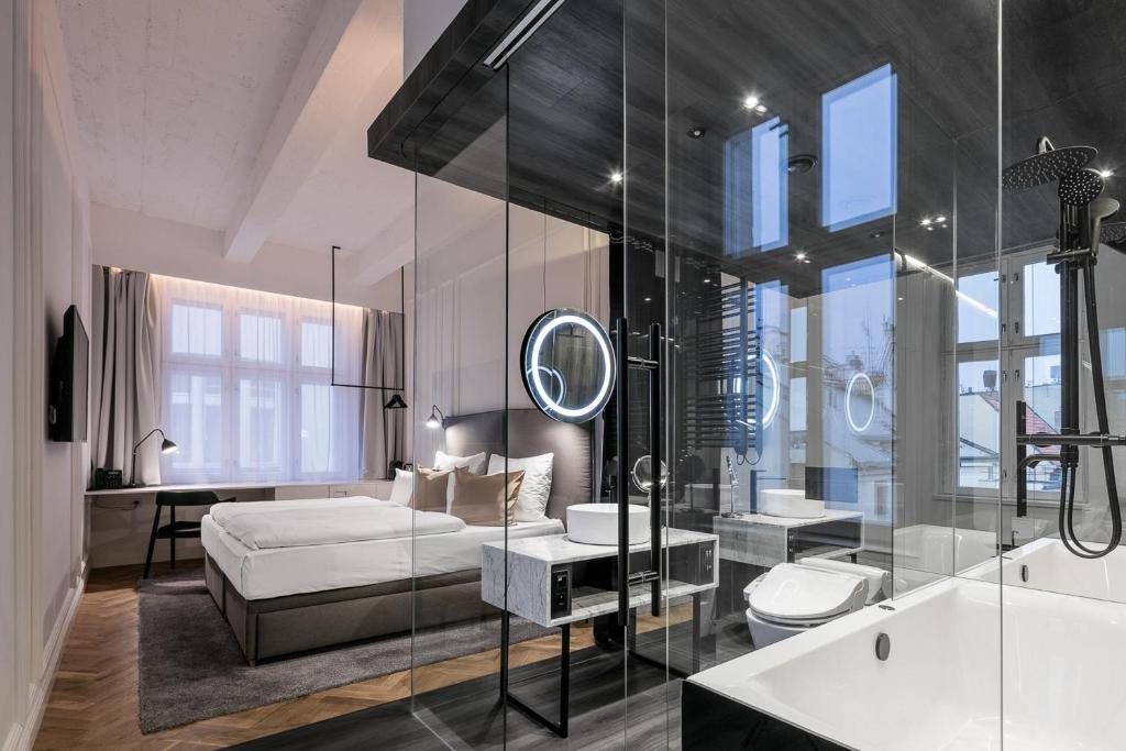 um quarto com uma cama e uma casa de banho com um espelho. em Pytloun Boutique Hotel Prague em Praga