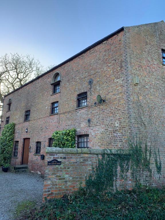 a large brick building with windows on the side of it at The Carriage House, Bilbrough York Sleeps 24 in Bilbrough