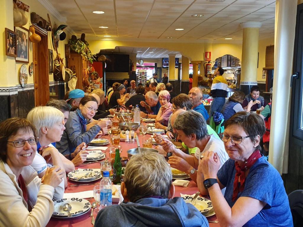 a group of people sitting at a long table eating at Hotel Sonia Chipude in El Cercado