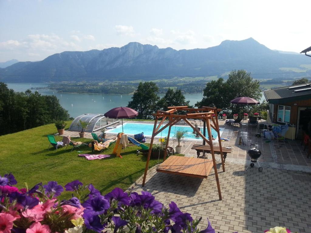a swimming pool with a view of a lake at Ferienhof Gassner in Mondsee