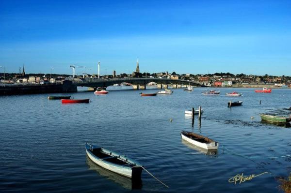 a group of boats in a river with a bridge at Glenhill B&B in Wexford