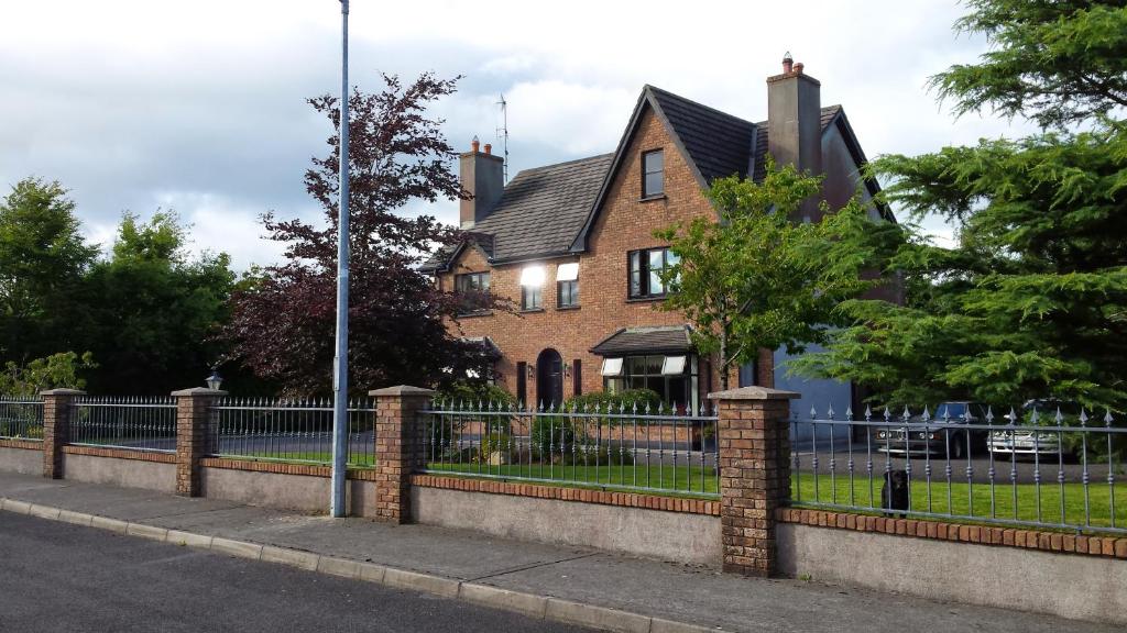 una casa di mattoni con una recinzione di fronte di Venetia House - small guesthouse a Galway