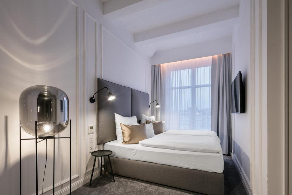 a hotel room with a bed and a window at Pytloun Boutique Hotel Prague in Prague