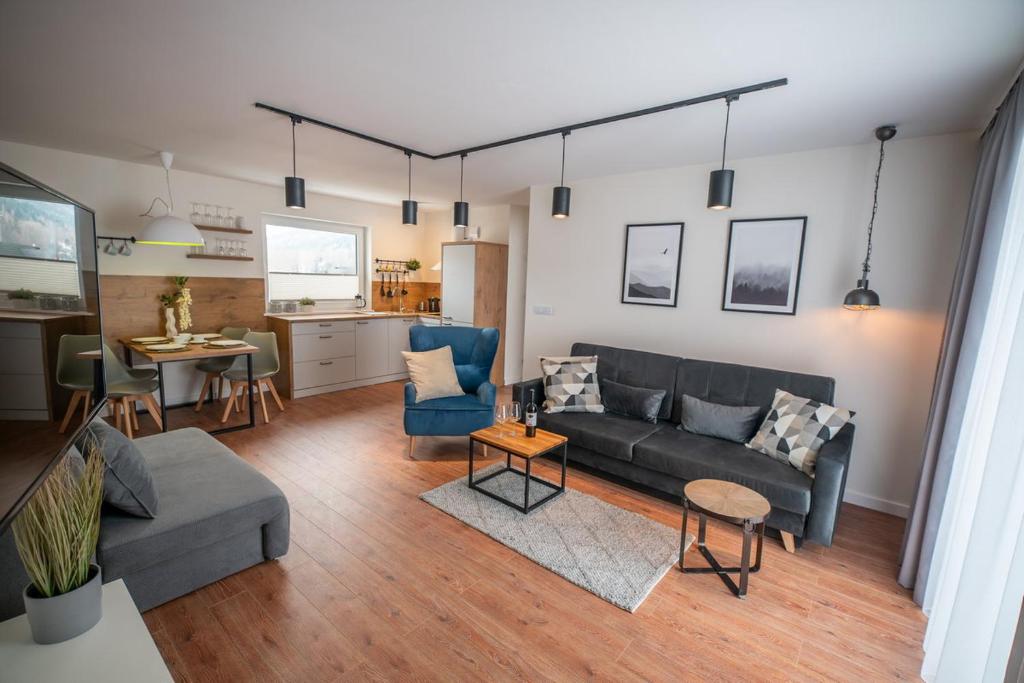a living room with a couch and a kitchen at Apartament Kasztanowy blisko centrum - Dream Apart in Szczyrk