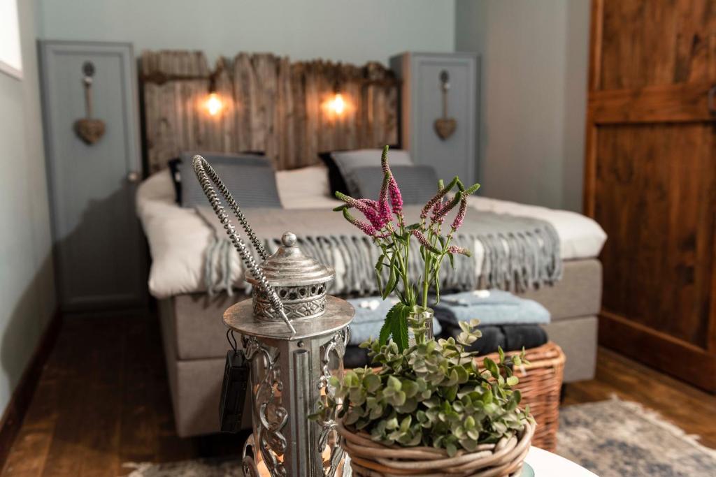 Sala de estar con cama y mesa con flores en B&B Bed en Omelet, en Wagenberg