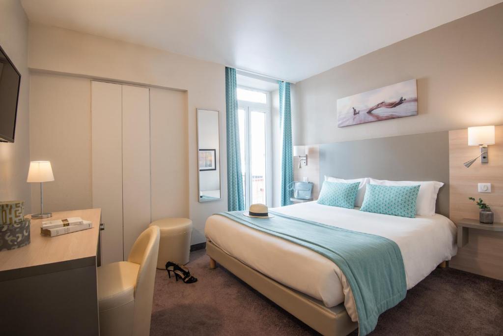 a hotel room with a bed and a window at Hotel Du Midi in Nice