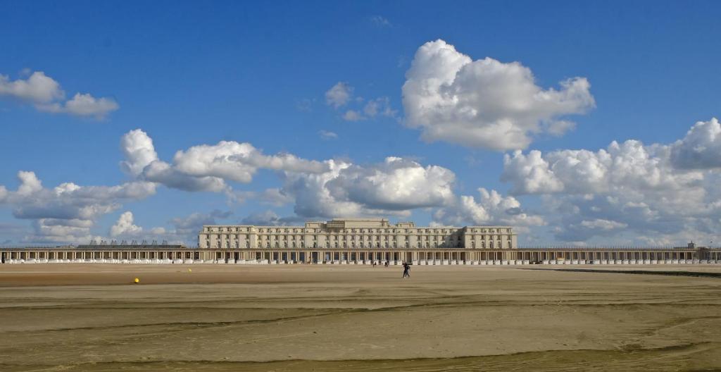 a large building in the middle of a field at Thermae Palace in Ostend
