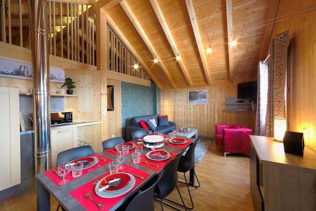 a dining room with a long table with red plates at Gîte du Bief de la Chaille in Les Rousses