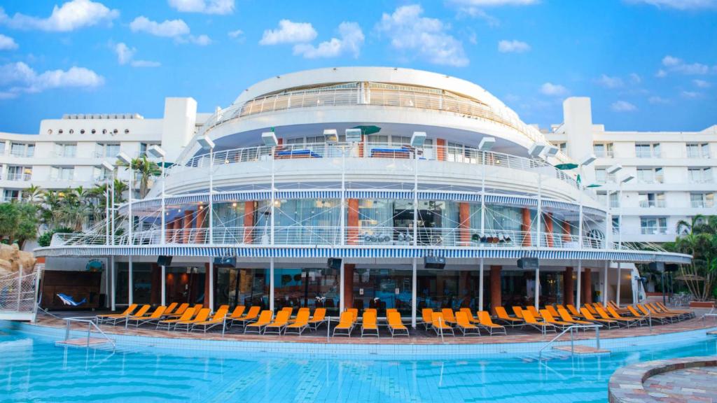un gran edificio con sillas y piscina en Club Hotel Eilat - All Suites Hotel en Eilat